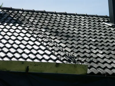 Under arbetet: nytvättade pannor som blänker i solen, stege längs takfallet
