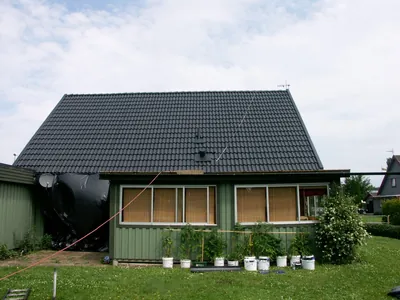 Efter: närbild på nybehandlade antracitpannor vid kanten av gaveln, med takantenn