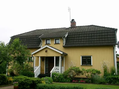 Före: gul trävilla med mossigt, urblekt pannetak som ser grått och smutsigt ut