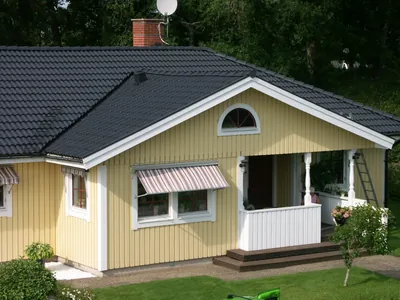 Efter: gul villa med glasad veranda, markis och nybehandlat tak i antracit