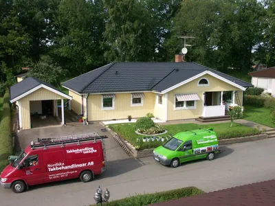 Efter: villan sedd uppifrån med carport och färdigt antracittak, fordon på uppfarten