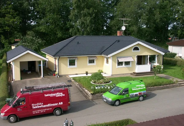 Gul enplansvilla med carport och nybehandlat antracittak, firmabil och skåpbil på uppfarten