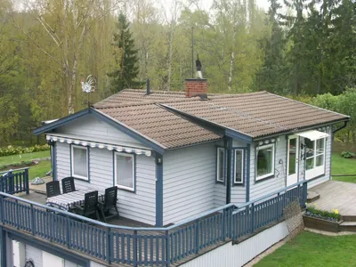 Före: ljusgrå villa med blå knutar och bleknat, brunt pannetak, sedd från uppsidan