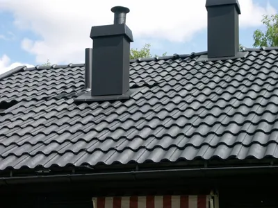 Efter: antracitgrå skorstenar och takfall med nymålade pannor, nära