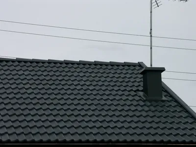 Efter: närbild på nymålade antracitpannor med skorsten och antenn