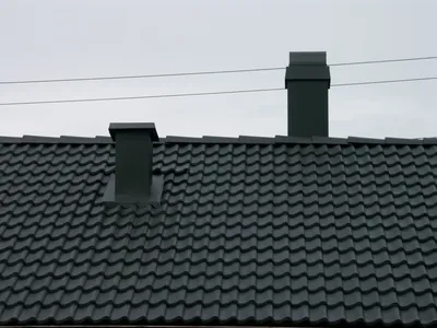 Efter: grova Zanda-pannor i jämn antracit intill två skorstenar
