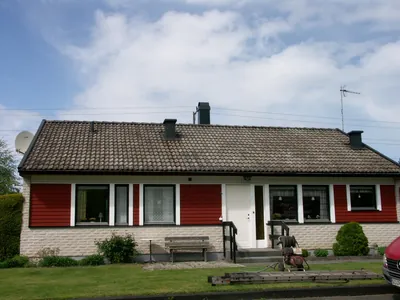 Före: röd villa med ljus tegelsockel och urblekt, mossigt tak, stege vid husväggen