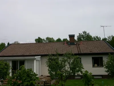Före: baksida med inglasad uteplats under ett brunt tak med smuts