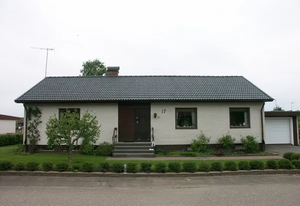 Vit tegelvilla med garage och nybehandlat antracitgrått tak av grova Zanda-pannor