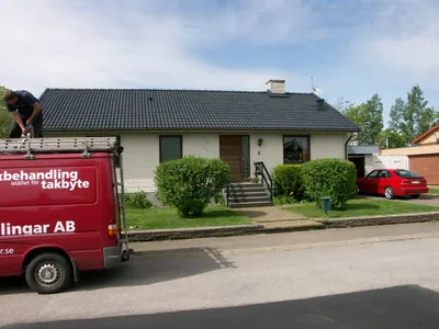 Efter: villan från gatan med färdigbehandlat antracittak, firmabilen parkerad framför