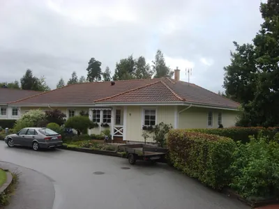 Före: gulpanelad villa med blekt, smutsigt brunt tak sedd från gatan