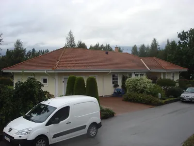 Före: villa med uppfart och matta bruna takpannor, vit skåpbil framför