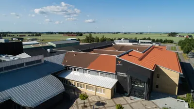 Före: Lagmansgymnasiet i Vara med mörka, ojämna takfall och entré med skolans namn