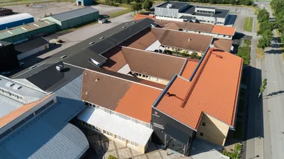 Före: skolans tak från drönare med blandade nyanser i brunt och orange på takfallen