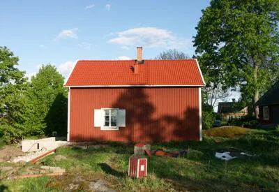 Rött trähus med tegelrött behandlat tak
