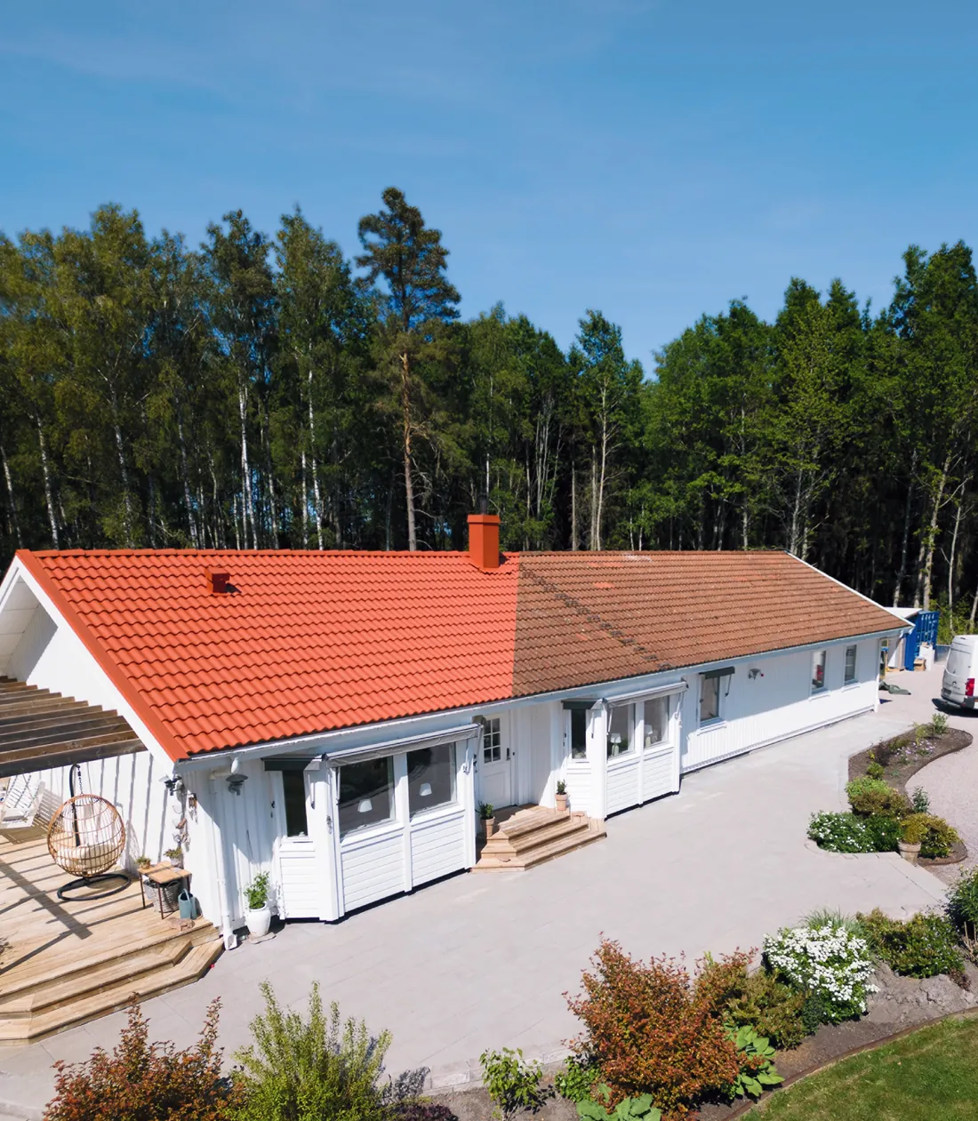Vit villa med nymålat tegelrött betongpannetak